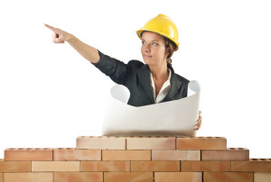 Businesswoman with drawings near brick wall