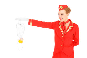 A picture of an attractive stewardess presenting an oxygen mask over white background